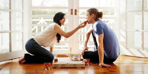 A tender moment where a loving wife feeds her husband, capturing the essence of care, affection, and emotional intimacy. The gesture reflects one of the daily habits of happy couples—nurturing each other with love and attention in simple, everyday acts.